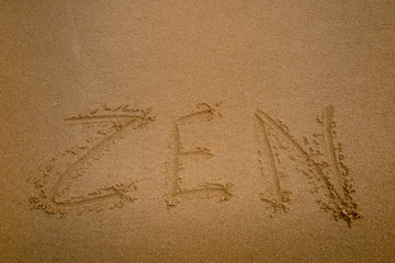 zen word written on the sand of a beach