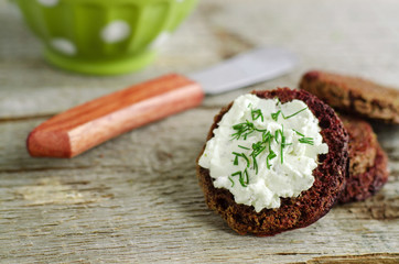 Small round rye toasts with cream cheese and dill