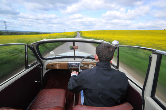 Open Top Classic Car Driving On A Summers Day