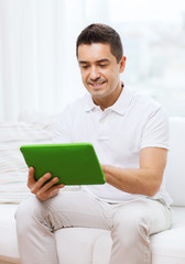 smiling man working with tablet pc at home