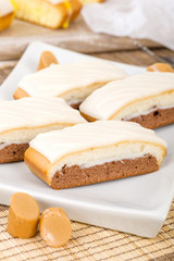 Chocolate, Caramel & Vanilla Cake - Slices of chocolate, caramel and vanilla cake topped with icing.
