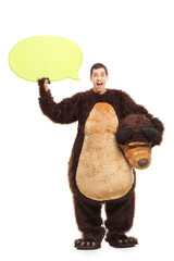 Young man in bear costume holding a speech bubble