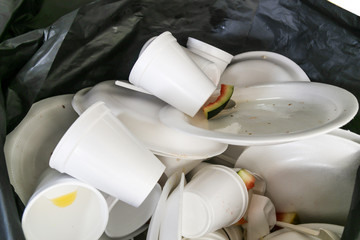 Fototapeta na wymiar Environmental unfriendly disposed styrofoam plates and cups in garbage bags
