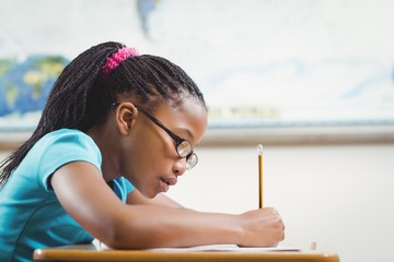Focused african american pupil working at her desk in a classroom
