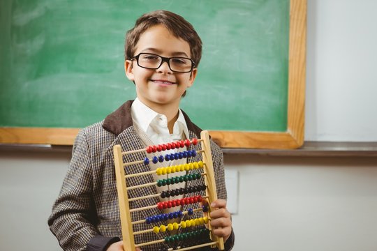 Smiling pupil dressed up as teacher holding abacus