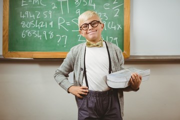 Smiling pupil dressed up as teacher holding books 