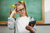 Cute pupil calculating with calculator in a classroom