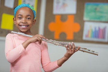 Cute pupil with flute in a classroom © WavebreakmediaMicro