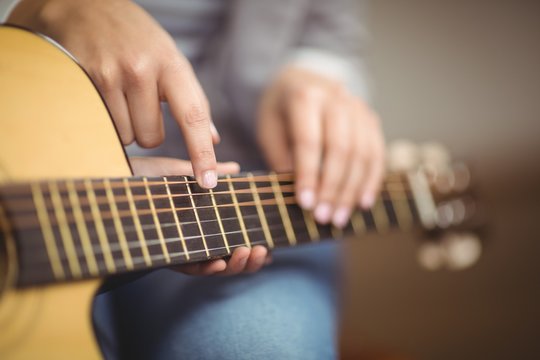 Teacher giving guitar lessons to pupil 