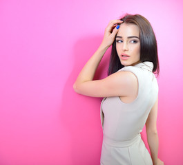 Portrait of young fashion girl over pink background