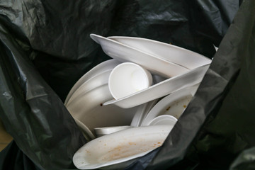 Environmental unfriendly disposed styrofoam plates and cups in garbage bags