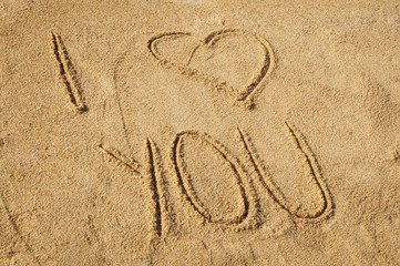 The words I Love You written in the sand on the beach