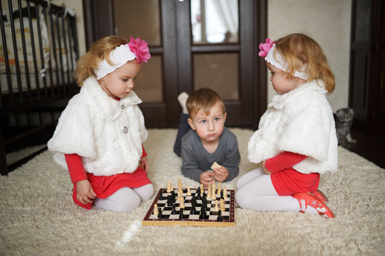 children playing chess lying on floor