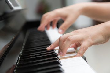 Fototapeta na wymiar Close up of woman hands playing piano