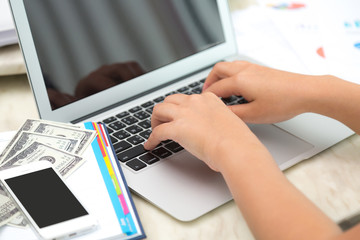Business woman hand typing on laptop keyboard with Financial cha