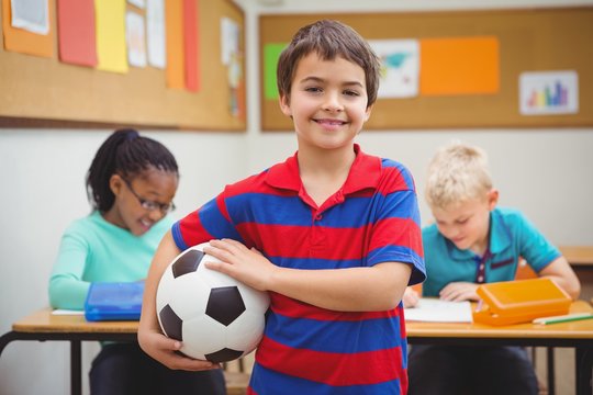 Smiling student holding a football