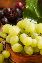 Green grapes in a wicker basket in a rustic style, selective foc