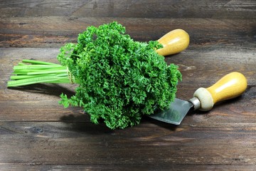 frische Petersilie mit Wiegemesser auf Holzhintergrund