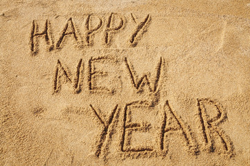 The words Happy New Year written in the sand on the beach