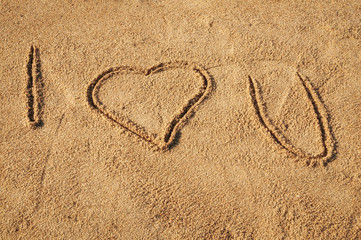 The words I Love You written in the sand on the beach