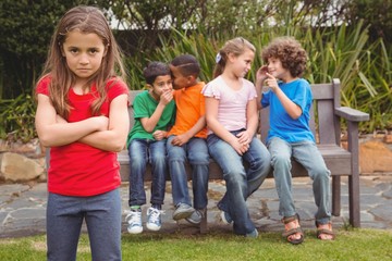 Upset child standing away from group