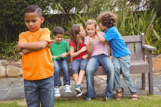 Upset child standing away from group
