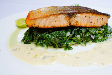 Salmon steak on spinach, selective focus