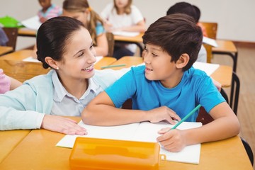 Teacher helping a little boy during class