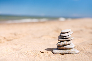 Fototapeta na wymiar Balance zen stones pyramid on the sea sand