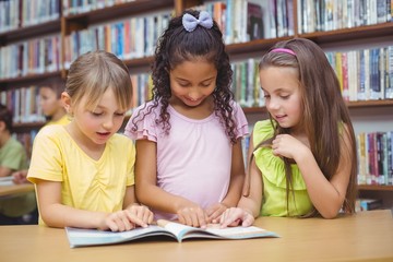 Pupils reading book together in library
