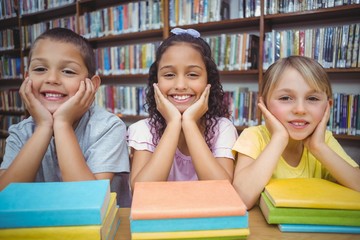 Pupils smiling at camera in library