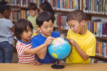 Fototapeta premium Pupils in library with globe