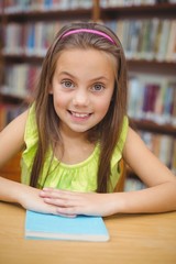 Pupil smiling at camera in library
