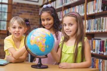 Fototapeta premium Pupils in library with globe