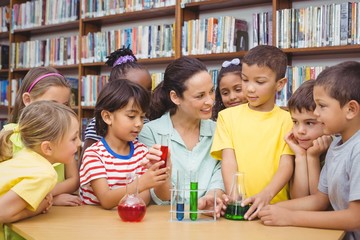 Pupils and teacher doing science in library