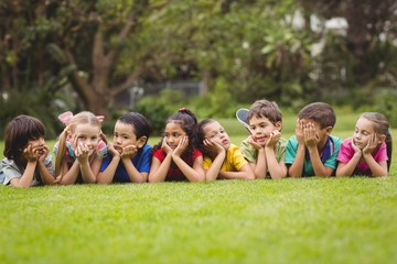Cute pupils lying on the grass outside 