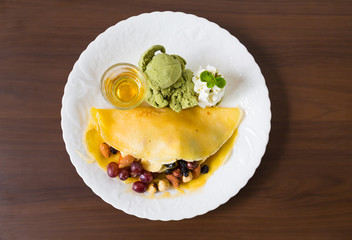 Pancake and fruit with ice cream on table