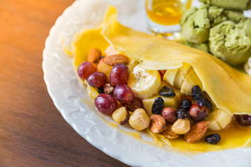 Pancake and fruit with ice cream on table