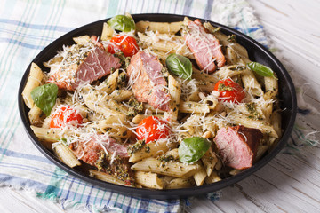 Delicious penne pasta with meat, parmesan and pesto sauce 

