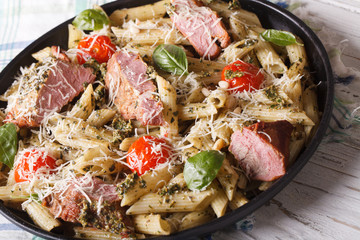 Italian pasta penne with meat, parmesan and pesto
