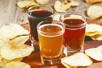 Three kinds of beer and potato chips, selective focus