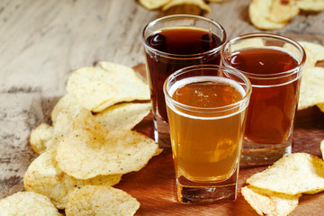 Three kinds of beer and potato chips, selective focus