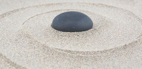 Fototapeta na wymiar Zen garden - spa stone in the sand. Meditation, spirituality and harmony concept