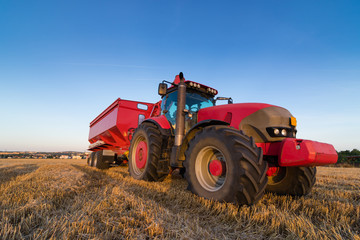 Agriculture tractor and trailer on a stubble field