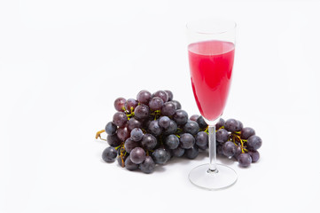 Glass of wine and  branch of grapes on  white background