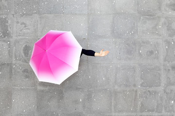 Image of a woman under umbrella checking if it's raining