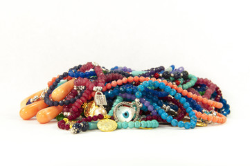 Close-up on very colourful handmade necklaces isolated by white background