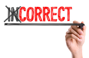 Hand with marker writing the word Incorrect/Correct
