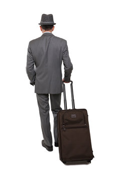 Rear view one caucasian business traveler man walking with suitcase
