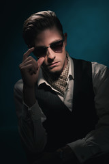 Handsome retro fashion man with vintage shades in waistcoat and scarf.